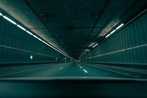 Driving through an empty underground tunnel in the teal and orange film look. Stock Photos