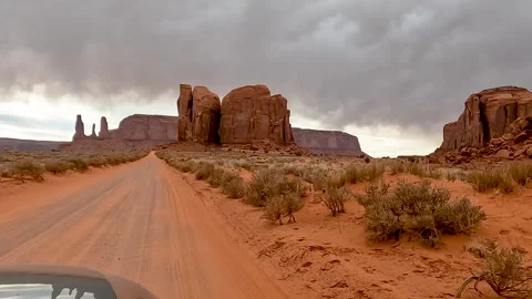 Driving Through Monument Valley Past the Three Sisters Rock Formation Stock Footage 309049537