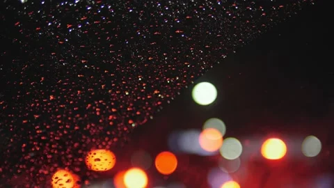 Driving Through the Rain: A Captivating Night Scene of City Lights and Glitterin Stock Footage 239998439