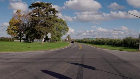Driving through rural intersection with stop sign on suburban road Stock Footage 332545997