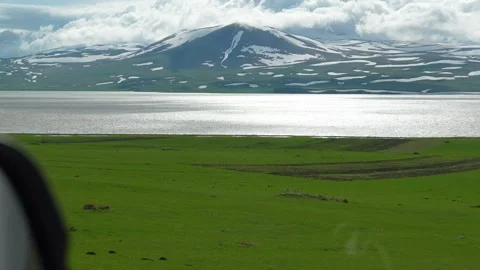 Driving through stunning green meadows and snowy mountains Vídeo Stock 340078286