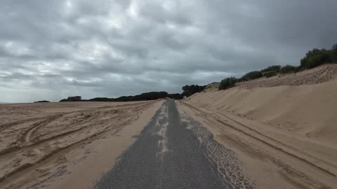 Driving through the Valdevaqueros dunes on a grey and rainy day, Spain Stock Footage 330292604