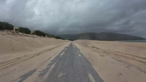 Driving through the Valdevaqueros dunes on a grey and rainy day, Spain Stock Footage 330292622