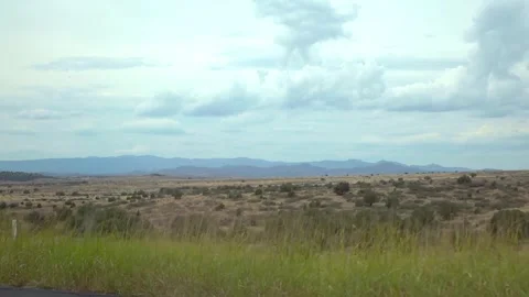 Driving through a vast desert landscape in Arizona with mountains in the di.. Stockbeeldmateriaal 280204875