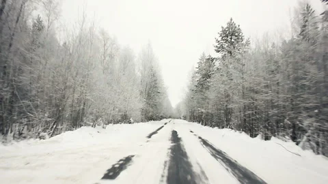 Driving through the winter forest on snowy road, first view. Camera outside the Stock-Footage 99885484