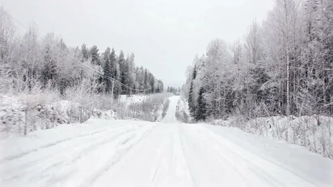 Driving through the winter forest on snowy road, first view. Camera outside the Stock Footage 99886098