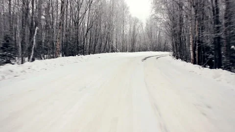 Driving through the winter forest on snowy road, first view. Camera outside the Stock-Footage 99886193