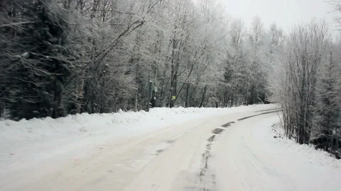 Driving through the winter forest on snowy road, first view. Camera outside the Stock Footage 99988872