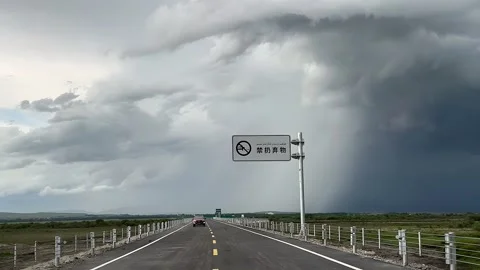 Driving Through Xinjiang Grasslands Under Dark Storm Clouds, China Stock Footage 336932853