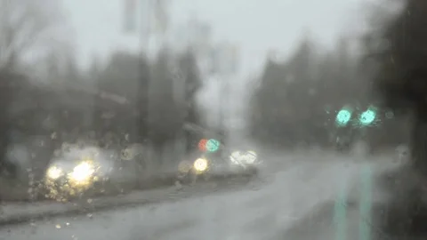 Driving through yellow traffic light in heavy rain, shallow focus through glass. Stock Footage 111988989