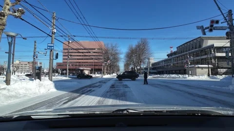 Driving toward snowy intersection with pedestrian crossing in Asahikawa Japan Vídeos de archivo 333314057