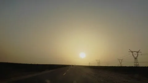 Driving toward the sunset on an empty road in Xinjiang Stock Footage 342723040