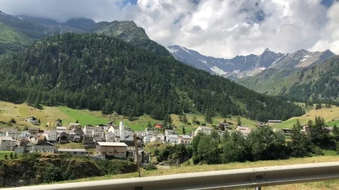 Driving by town below mountain in a valley of Switzerland Video stock 95082261