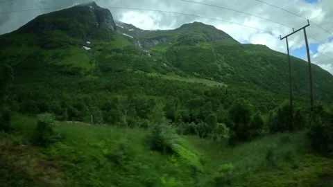 Driving tracking shot of green mountain slope with cascading waterfall in Norway Vidéo 343833865