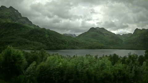 Driving tracking shot past mountain lake and green hills in Norway Stock-Footage 343833872