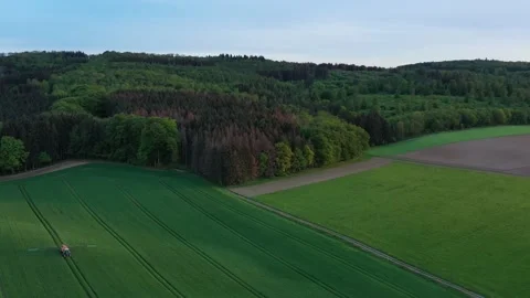 Driving tractor across the field and spraying fertilizer Stock Footage 134404637