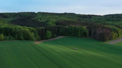 Driving tractor across the field and spraying fertilizer Stock Footage 134404670