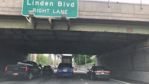 Driving under overpass bridge Linden Boulevard sign on highway in New York City 库存影片 107693683