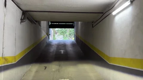 Driving up underground parking exit ramp toward daylight Vidéo 338195025