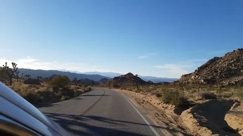 Driving view above a car window, on a asphalt road in Joshua tree national .. Stock Footage 72760739
