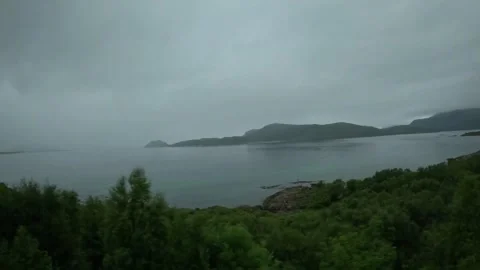 Driving view of coastal cliff and distant misty islands over Norwegian fjord Video stock 341814619