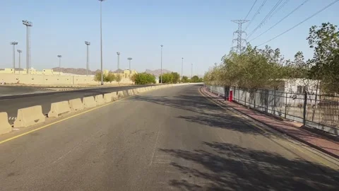 Driving view on empty highway in desert region lined with fences, trees, and Video stock 340195281