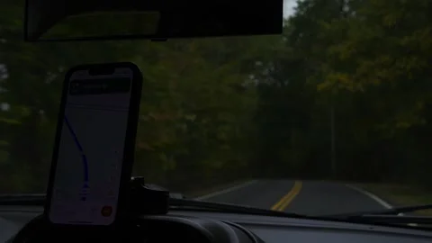 Driving view inside a car featuring a smartphone mounted with GPS... Stockbeeldmateriaal 319881191