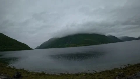 Driving view of moody cloud capped mountain over fjord in Norway Stock-Footage 341814613