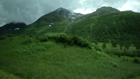 Driving view past lush green valley stream and mountain waterfall in Norway 库存影片 343833867