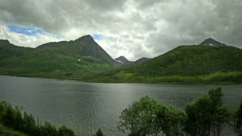 Driving view past scenic mountain lake and sharp peaks in Norway 库存影片 343833854