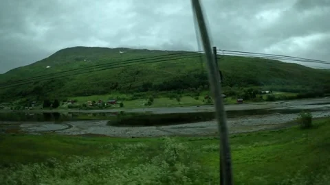 Driving view of three traditional red cabins in green Norwegian valley 库存影片 341814607