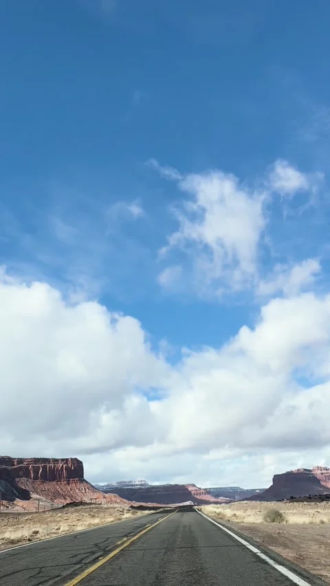 Driving a winding road stretched through dramatic desert landscapes under a.. Stock Footage 286729168