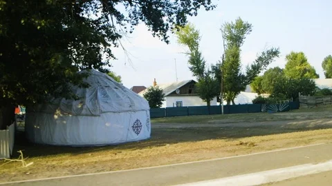 Driving by a yurt under the shadow of a tree during sunset in Kazakhstan Stock Footage 122598272