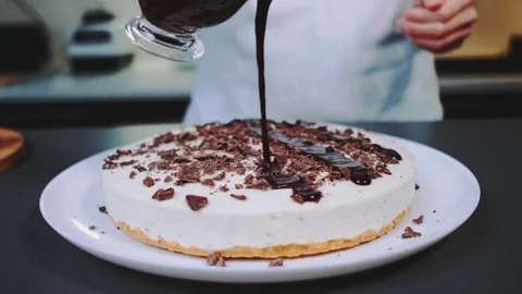 Drizzle melted chocolate on top of the cake Stock-Footage 249730779