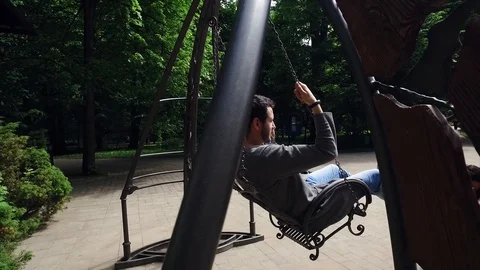DROGOBYCH, UKRAINE - 3 MAY, 2019: Young man with beard swinging alone in the Video stock 108849469