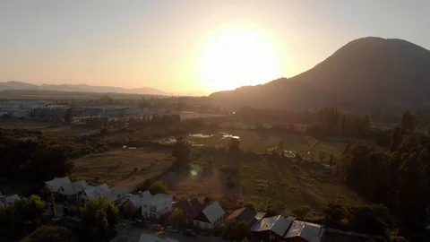 Dron aerial view sunset tilti up mountain field houses town Stock Footage 105507930