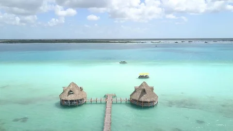 Drone of 2 Palm Huts and Dock on Bright Blue/Turquoise Water in Mexico Vídeo Stock 89811959