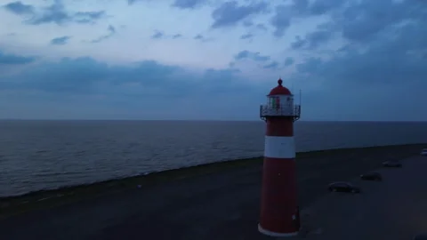 Drone 4K Cinematic Move Around Lighthouse at Dusk with Colorful Sky and Ship Stock Footage 295950744
