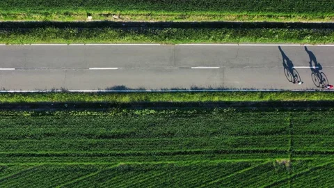 Drone 4k clip of two cyclist and their shadows projecting on the road at sunset Vídeo Stock 154745245