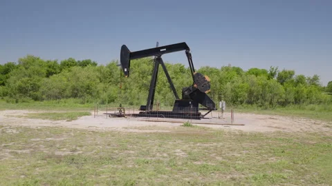 Drone 4K of a field with an oil pump jack in the spring and summer. Stock Footage 335138738