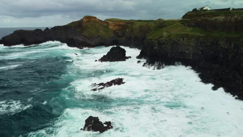 Drone 4K forward over inlet with cliffs, waves, and green vegetation Stock Footage 315252563