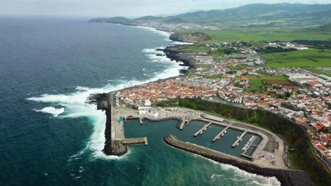Drone 4K tracking over coastal city with waves and distant mountains Stock Footage 315249406