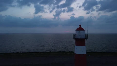 Drone 4K View of Tranquil Lighthouse at Evening Under Dramatic Cloudy Sky Stock Footage 295951544