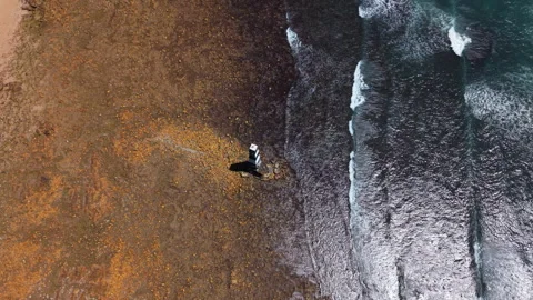 Drone Above Beacon Moving Backwards to Reveal Coastline, Ocean, Waves, and Dista Stock Footage 306317364