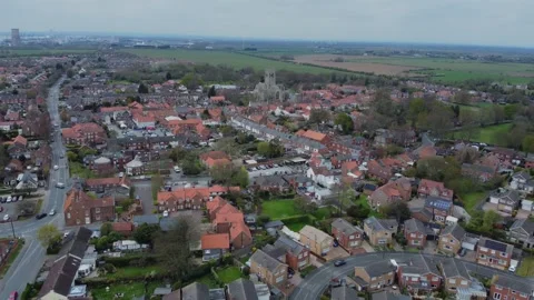 Drone above middle class houses in English market town, church, house rooftops. Stock Footage 306464045