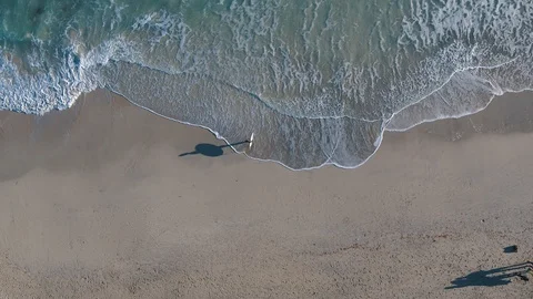 Drone above surfer standing on beach with waves Stock Footage 100262847