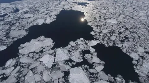 Drone abstract ice floes and hummocks drifting frozen Lake Baikal Sun reflection Stock Footage 317963154