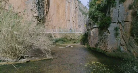 Drone advancing inside the river between and elderly person walking Stock Footage 124387470