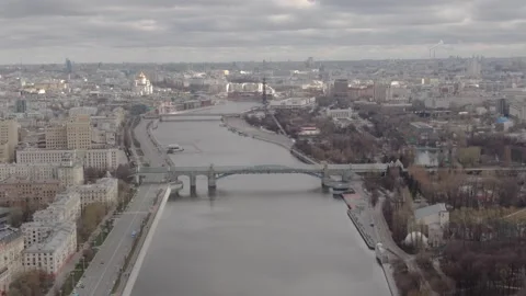 Drone advancing over river through cityscape Stockbeeldmateriaal 324875181