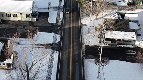 Drone Aerial Backward Tracking to Overhead Shot: Dark Sedan in Snowy Suburb Stock Footage 296074974
